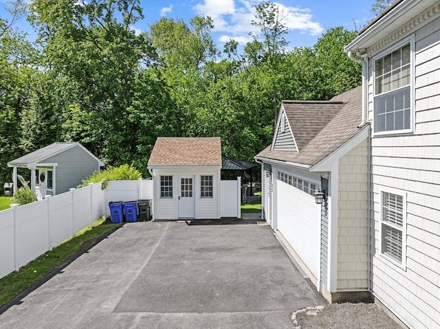 77 Columbus Dr, Fall River, MA 02720 - view of patio with asphalt driveway, a garage, and an outdoor structure