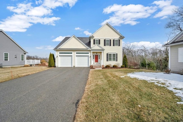 traditional-style house with a garage, driveway, and a front lawn