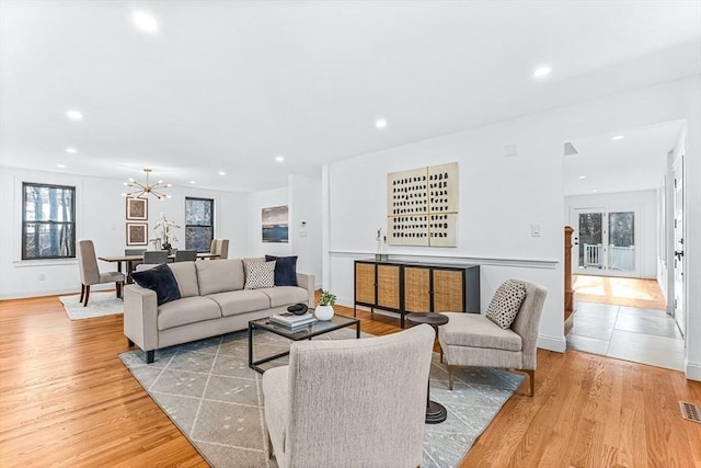 living room with recessed lighting, light wood-type flooring, visible vents, and a notable chandelier