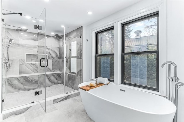 bathroom featuring marble finish floor, a soaking tub, and a marble finish shower