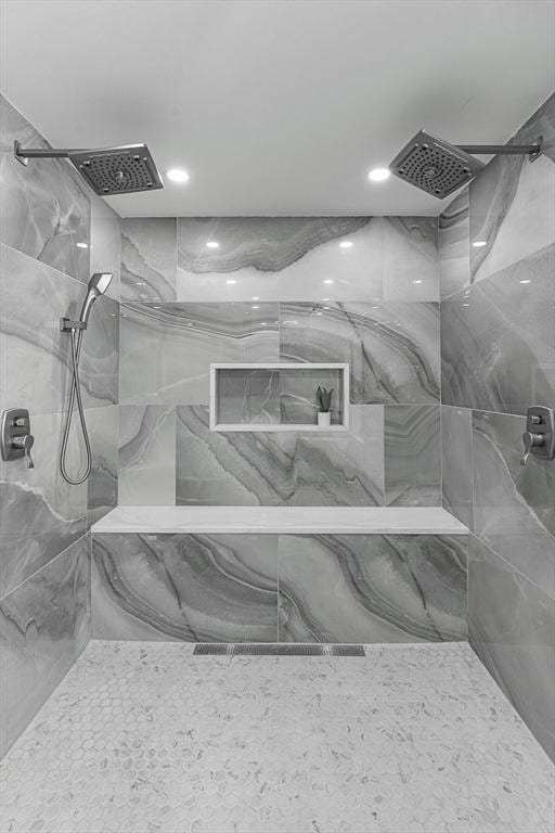 bathroom featuring a marble finish shower