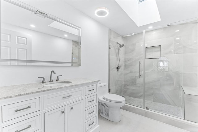 bathroom featuring toilet, a skylight, vanity, tile patterned floors, and a stall shower