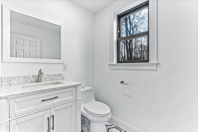 bathroom featuring marble finish floor, vanity, toilet, and baseboards