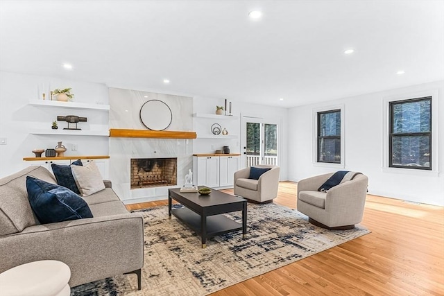 living room with a tile fireplace, recessed lighting, and wood finished floors