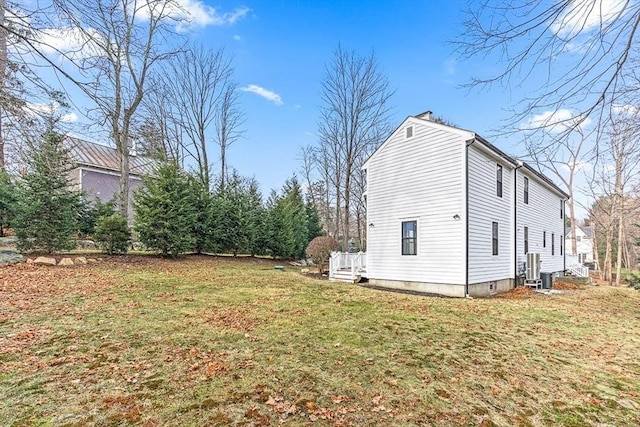 view of property exterior with central air condition unit and a lawn