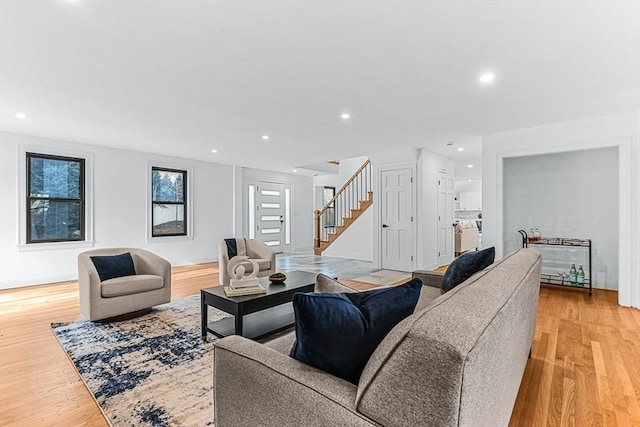 living area featuring stairs, light wood-type flooring, baseboards, and recessed lighting