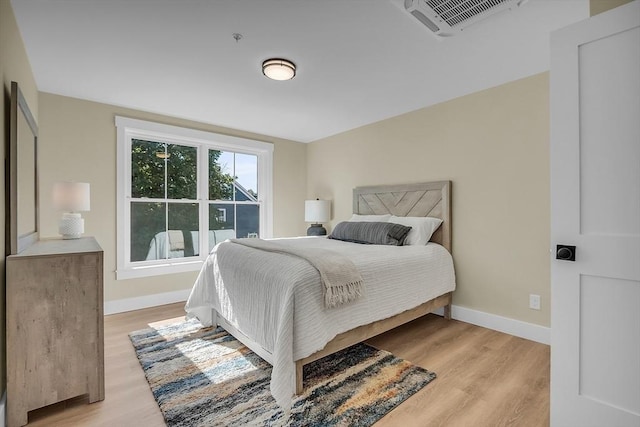bedroom featuring light wood-style floors, baseboards, and visible vents