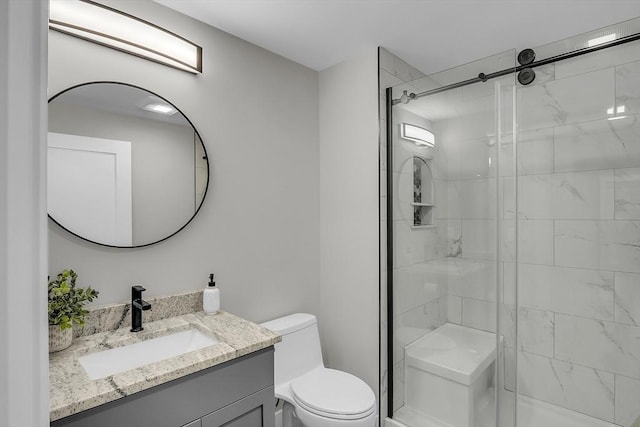 full bath with vanity, a stall shower, and toilet