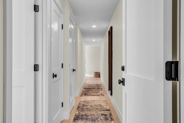 corridor with recessed lighting, baseboards, and light wood finished floors