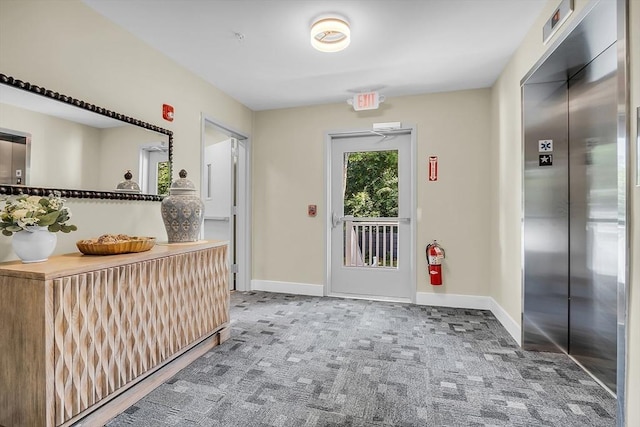 interior space with carpet floors, baseboards, and elevator