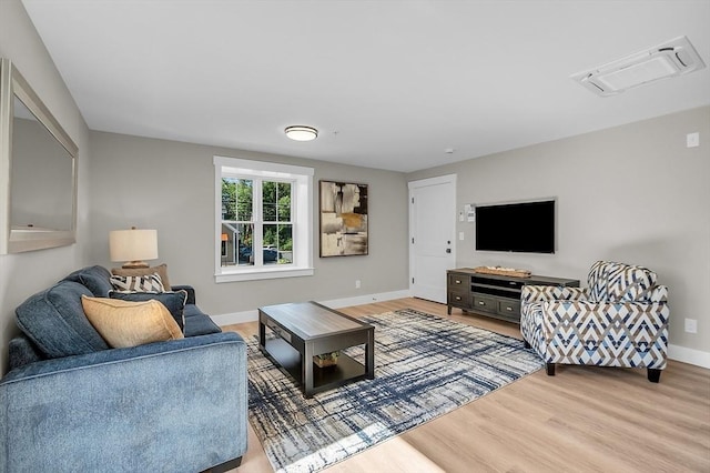living area featuring baseboards and light wood finished floors