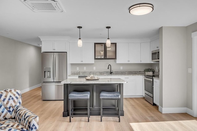 kitchen with stainless steel appliances, baseboards, white cabinetry, and light wood finished floors