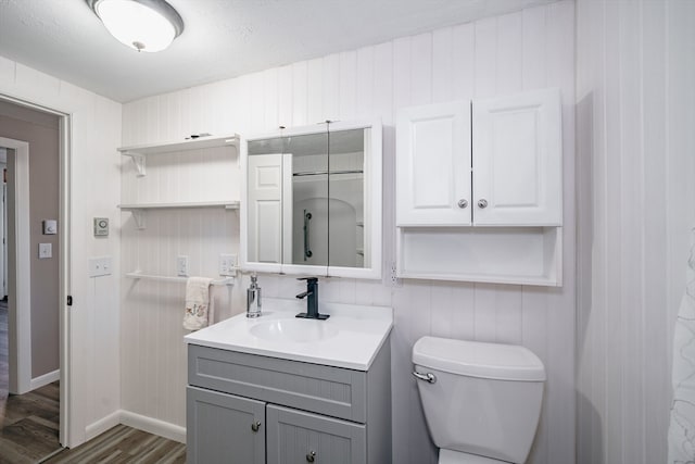 bathroom featuring vanity, hardwood / wood-style floors, toilet, and a textured ceiling