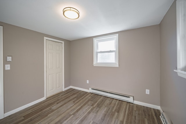 unfurnished bedroom with a closet, a baseboard radiator, and light hardwood / wood-style floors