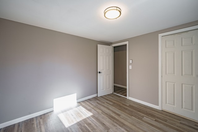 unfurnished bedroom with a closet and wood-type flooring