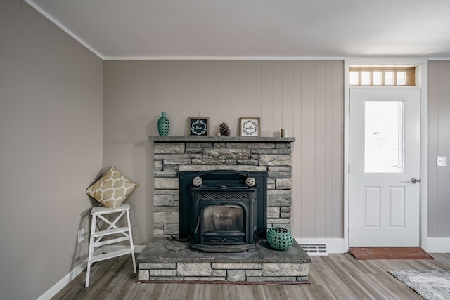 interior details with wood-type flooring, crown molding, and wood walls