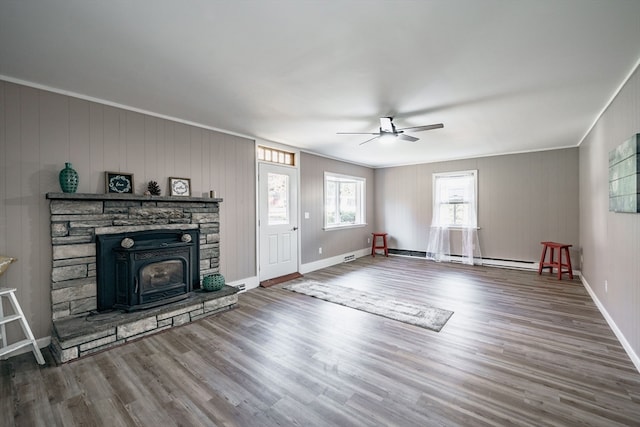 unfurnished living room with ornamental molding, ceiling fan, hardwood / wood-style flooring, and wood walls