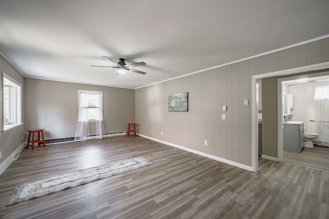 spare room with a wealth of natural light, crown molding, ceiling fan, and wood-type flooring