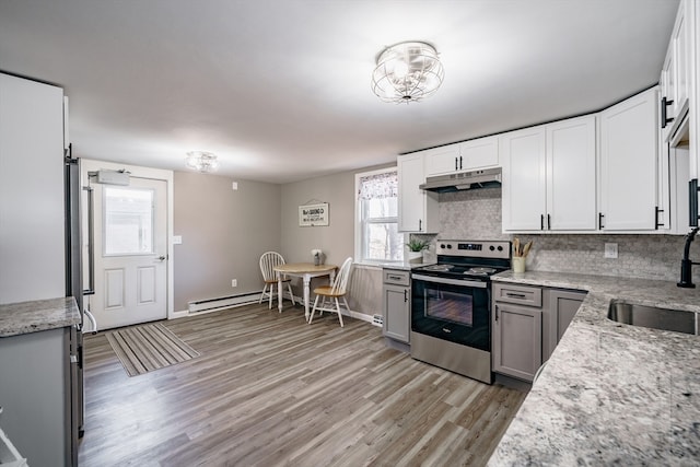 kitchen with sink, tasteful backsplash, electric range, a baseboard heating unit, and light wood-type flooring