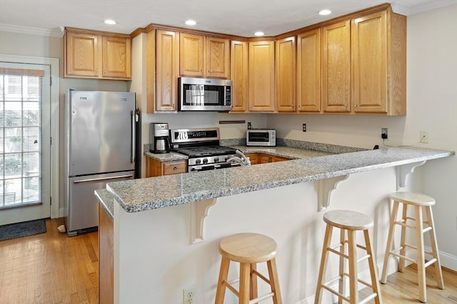 57 Alma Ave Unit 57, Belmont, MA 02478 - kitchen with stainless steel appliances, ornamental molding, light wood-style floors, recessed lighting, and a peninsula