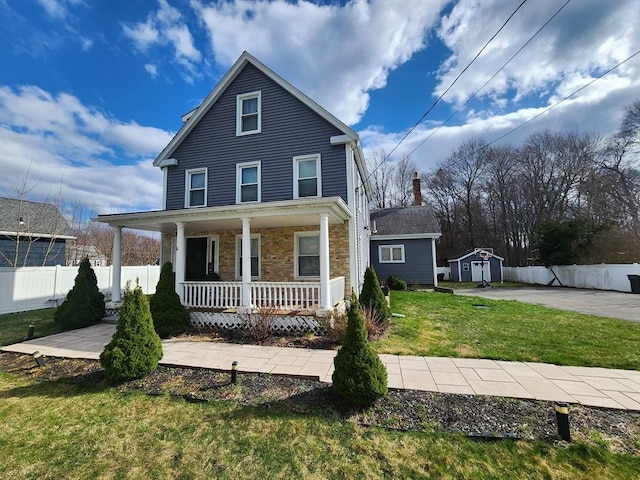 6 Pond St, Avon, MA 02322 - traditional-style home featuring a front yard, a porch, fence, and an outbuilding