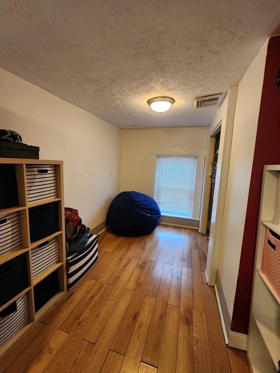 6 Pond St, Avon, MA 02322 - hallway with baseboards, visible vents, hardwood / wood-style flooring, and a textured ceiling