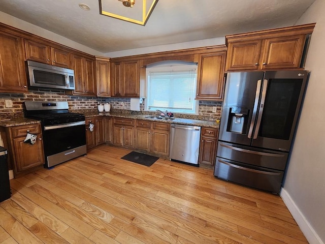 6 Pond St, Avon, MA 02322 - kitchen with light wood-style floors, a sink, stainless steel appliances, decorative backsplash, and baseboards