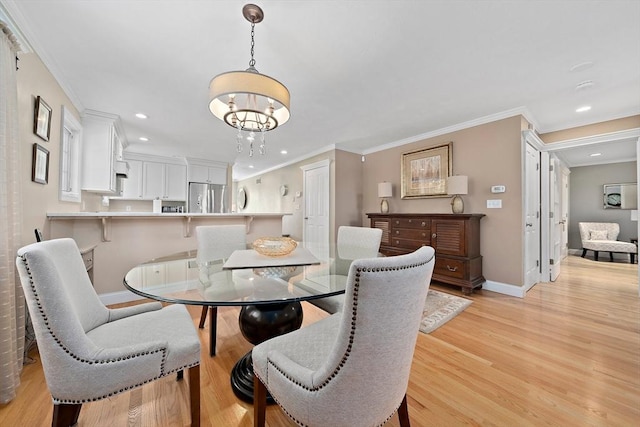 dining area featuring ornamental molding, an inviting chandelier, and light hardwood / wood-style flooring