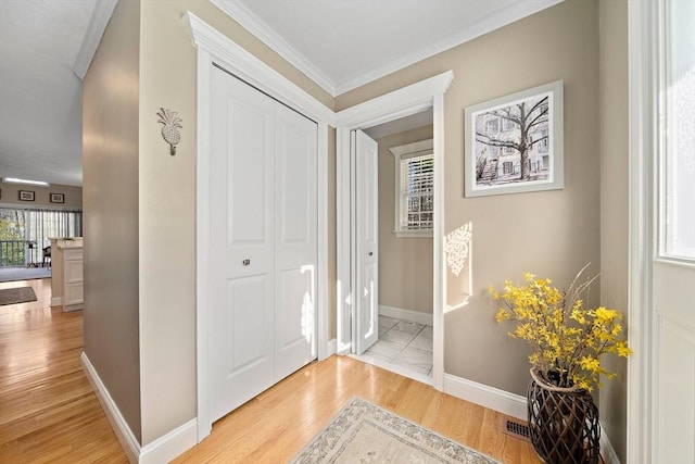 hall with crown molding and light hardwood / wood-style flooring