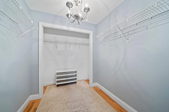 spacious closet featuring hardwood / wood-style flooring and a chandelier