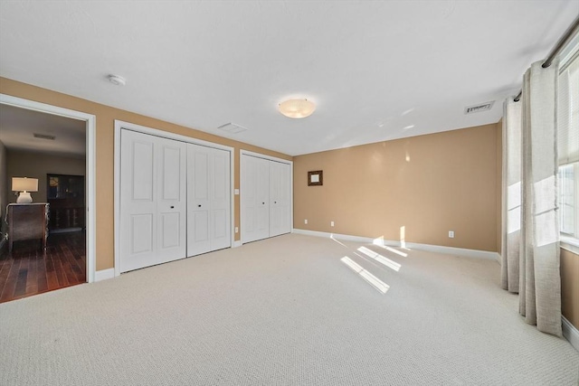 carpeted bedroom featuring two closets