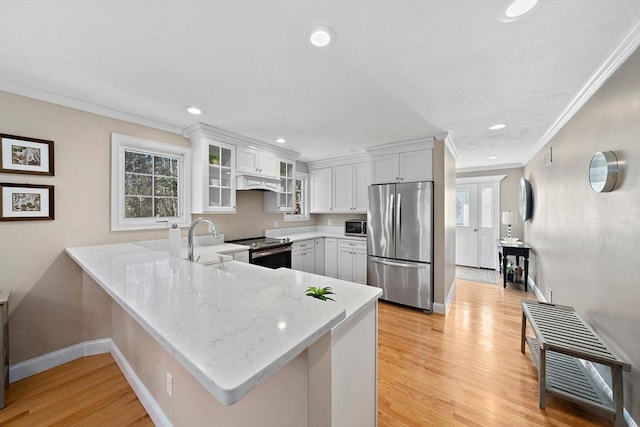 kitchen featuring white cabinetry, stainless steel appliances, kitchen peninsula, and light wood-type flooring