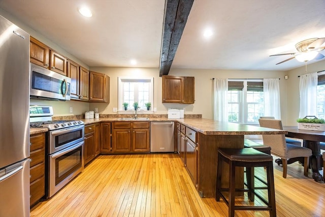 495 Creek St, Wrentham, MA 02093 - kitchen with appliances with stainless steel finishes, a peninsula, a sink, a kitchen breakfast bar, and healthy amount of natural light
