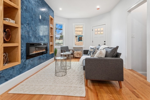 living room featuring light hardwood / wood-style flooring and a large fireplace