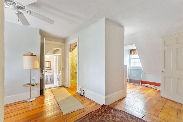 interior space featuring hardwood / wood-style flooring, ceiling fan, and baseboards