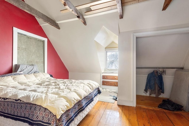 bedroom featuring vaulted ceiling with beams, a closet, and wood-type flooring