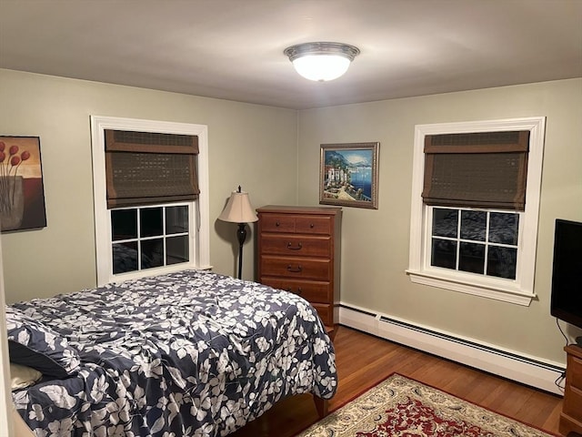 bedroom featuring hardwood / wood-style floors and baseboard heating