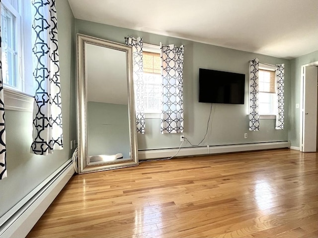 interior space with baseboard heating and light hardwood / wood-style flooring