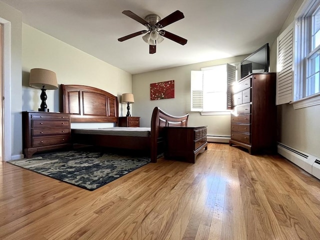 bedroom featuring a baseboard heating unit, light wood-type flooring, and ceiling fan