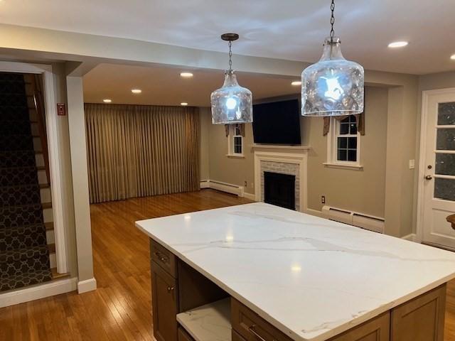 kitchen with pendant lighting, a baseboard radiator, and hardwood / wood-style floors