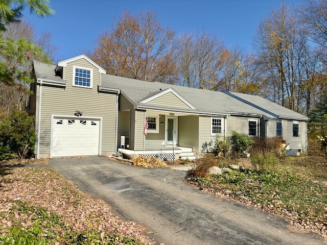 ranch-style home featuring covered porch and a garage