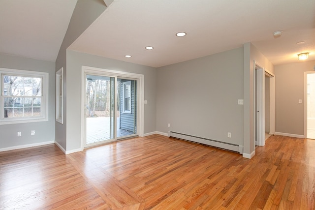 unfurnished room with light wood-type flooring, a baseboard radiator, and lofted ceiling