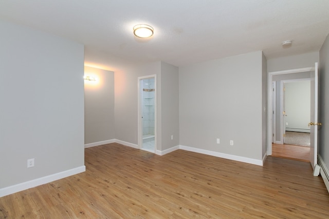 spare room featuring light hardwood / wood-style flooring and a baseboard heating unit