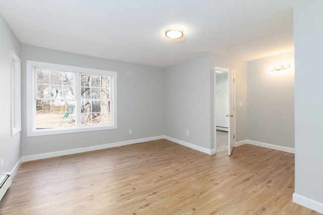 empty room featuring light hardwood / wood-style floors and a baseboard heating unit