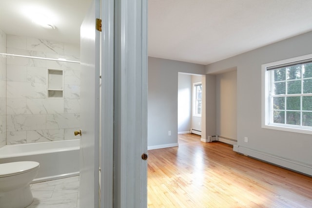 bathroom featuring a wealth of natural light, toilet, and hardwood / wood-style flooring