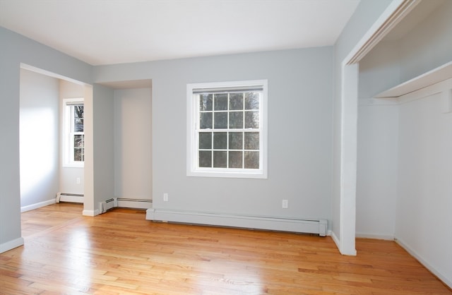 unfurnished bedroom with light hardwood / wood-style floors and a baseboard radiator