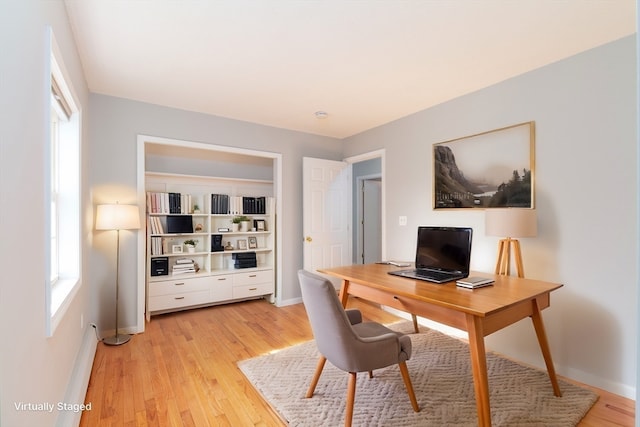 home office with light hardwood / wood-style floors