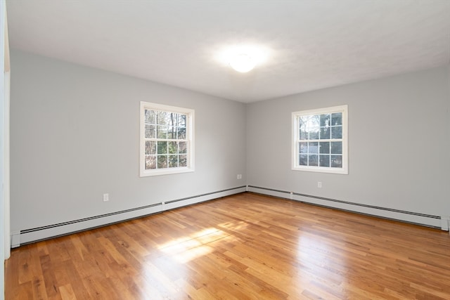 spare room featuring light wood-type flooring and a baseboard heating unit