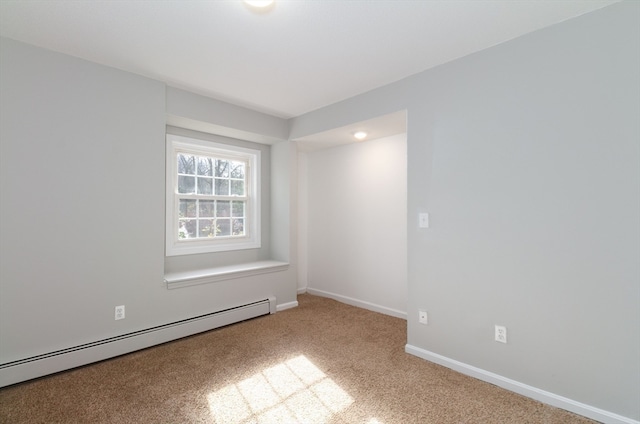 carpeted spare room featuring a baseboard radiator