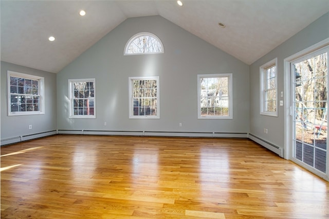 unfurnished living room with a healthy amount of sunlight, high vaulted ceiling, and light hardwood / wood-style flooring